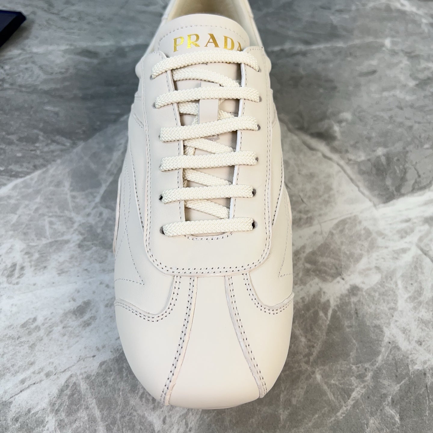 PRADA 25S MONTECARLO ANTIQUED SNEAKERS IN CHALK WHITE NAPPA LEATHER